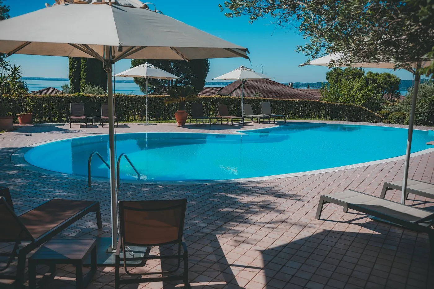 Piscina panoramica con lettini e ombrelloni vista lago