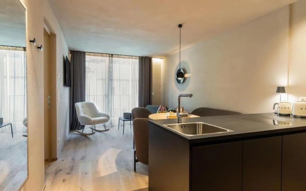 Cucina open space con isola nera e zona living luminosa