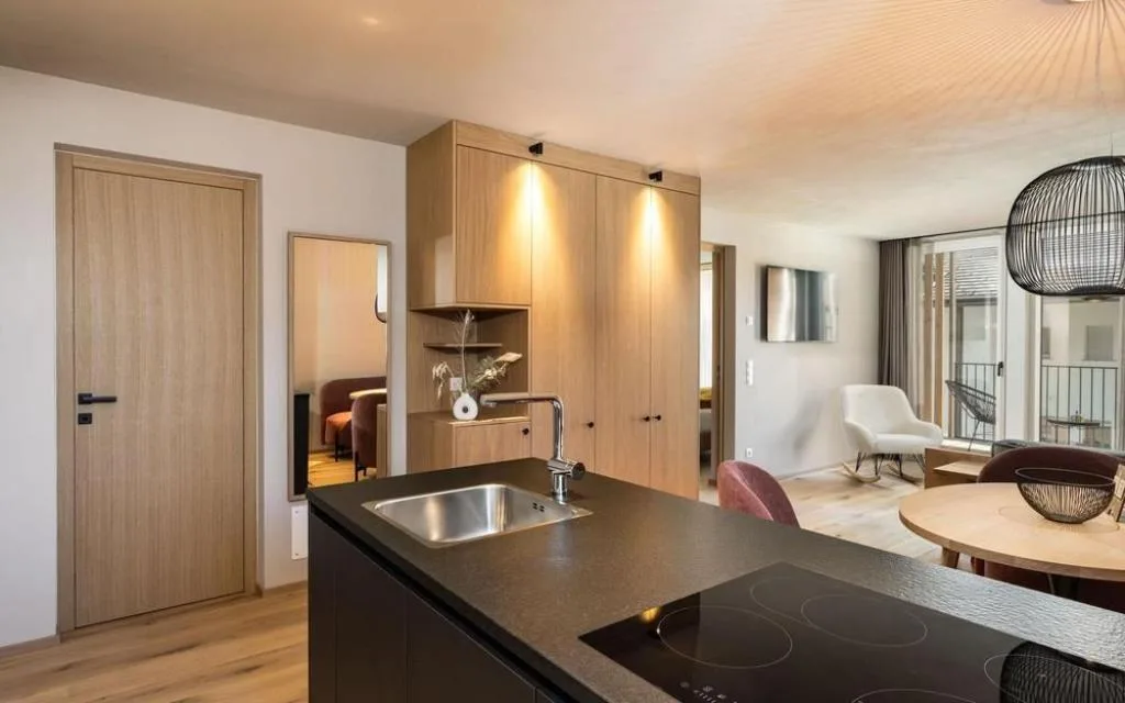 Cucina con piano cottura a induzione e zona living sullo sfondo