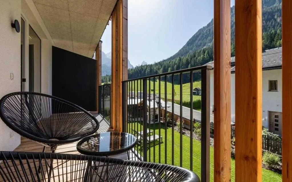 Balcone con poltrone in legno e vista sui prati e le montagne