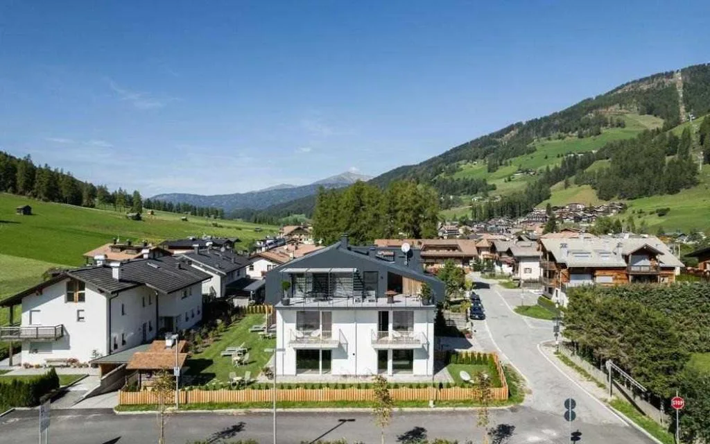 Vista aerea dell'edificio nel villaggio alpino circondato dal verde