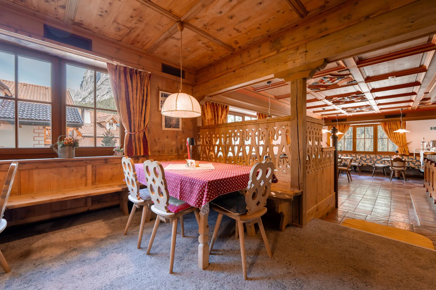 Sala da pranzo in stile alpino con rivestimenti in legno e vista sulle montagne
