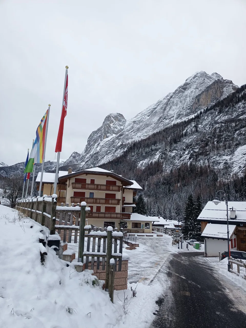 Ingresso dell'hotel con bandiere e montagne innevate sullo sfondo