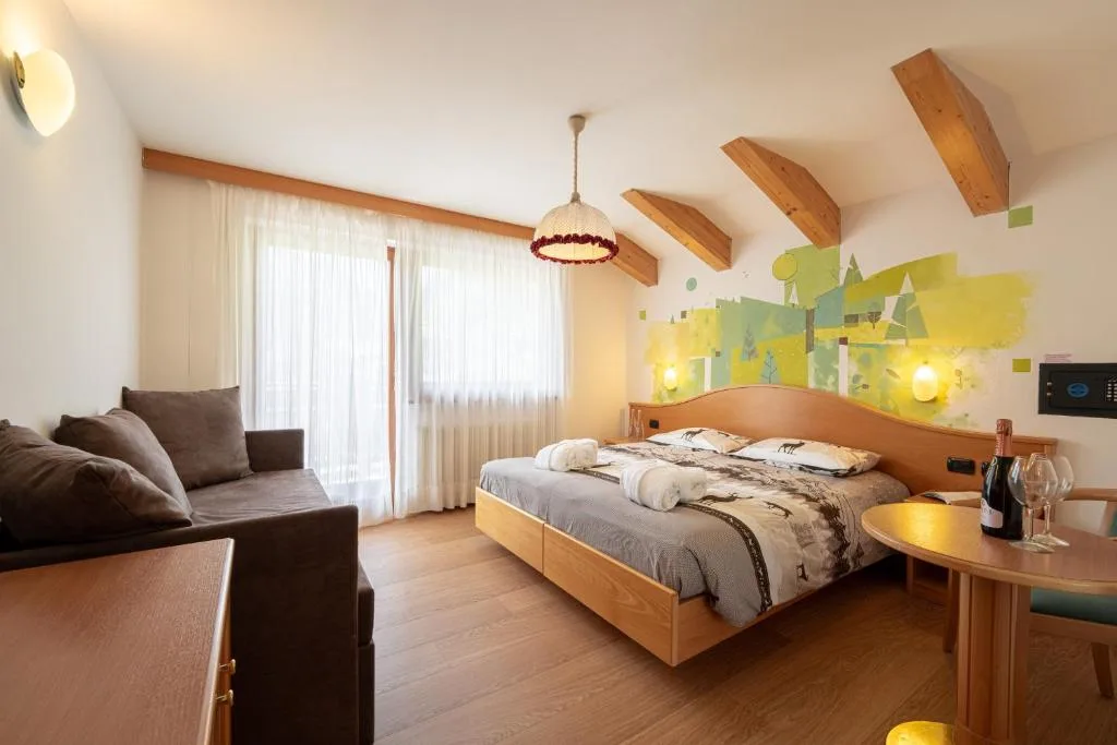 Camera da letto matrimoniale con decorazione murale colorata e divano