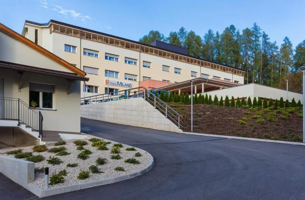 Ingresso dell'Hotel Milano con vialetto e aiuole fiorite in estate