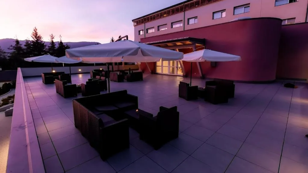 Terrazza con divani e ombrelloni al tramonto con cielo rosato