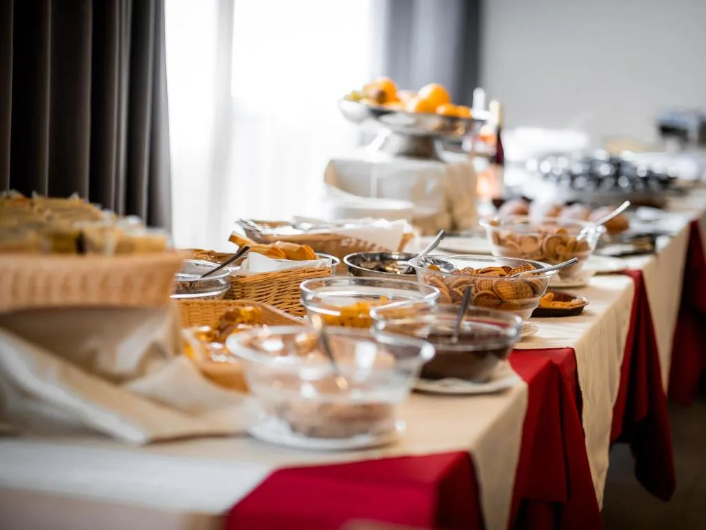 Tavolo con buffet di colazione ricco di cereali, pane e frutta