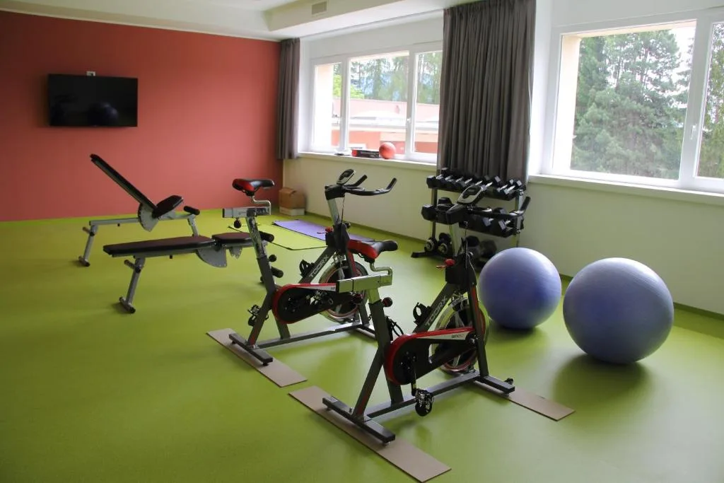 Sala fitness con cyclette, panca pesi e palle da ginnastica