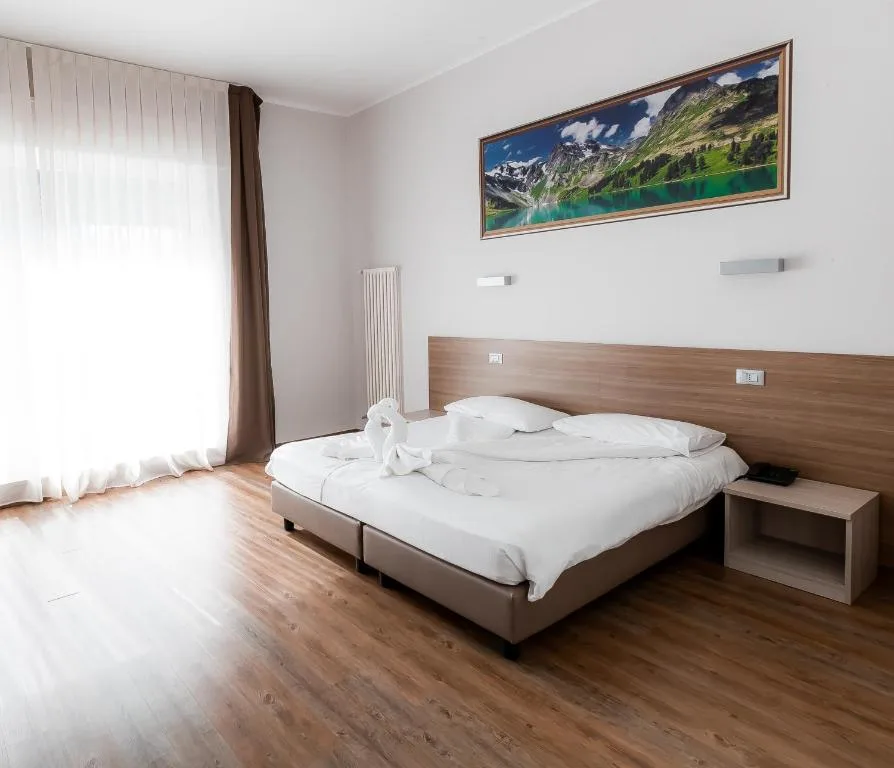 Camera luminosa con letto matrimoniale, parquet e ampia finestra