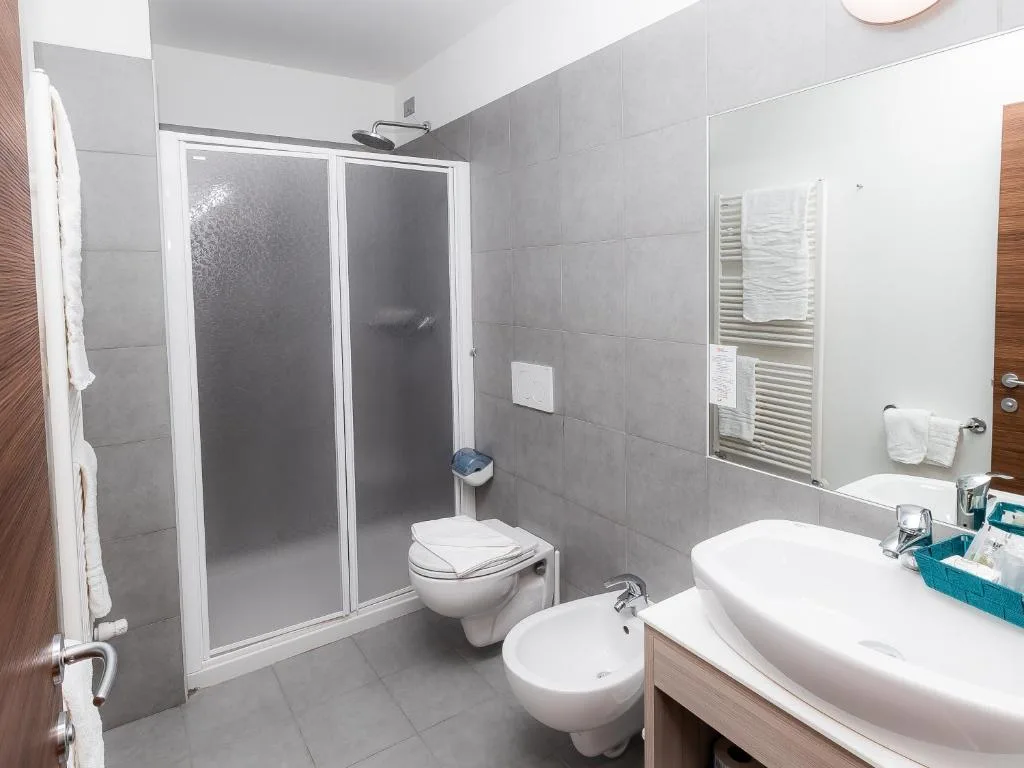 Bagno moderno con doccia, WC, bidet e lavabo con specchio