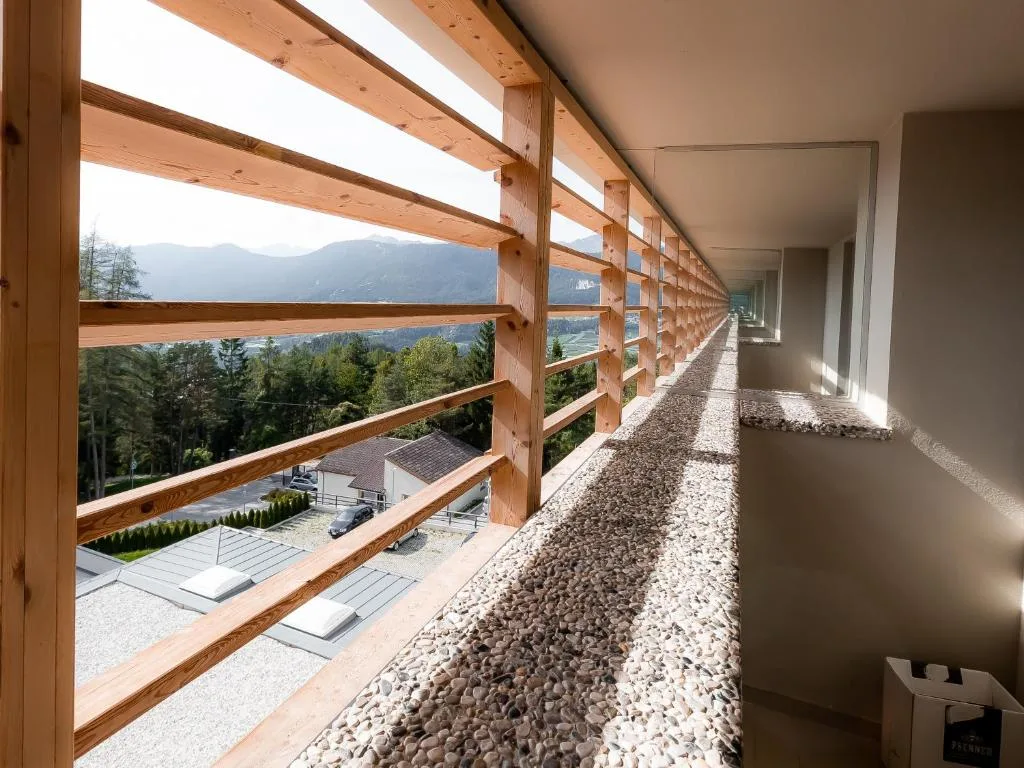 Ballatoio esterno con ringhiera in legno e vista sulle montagne