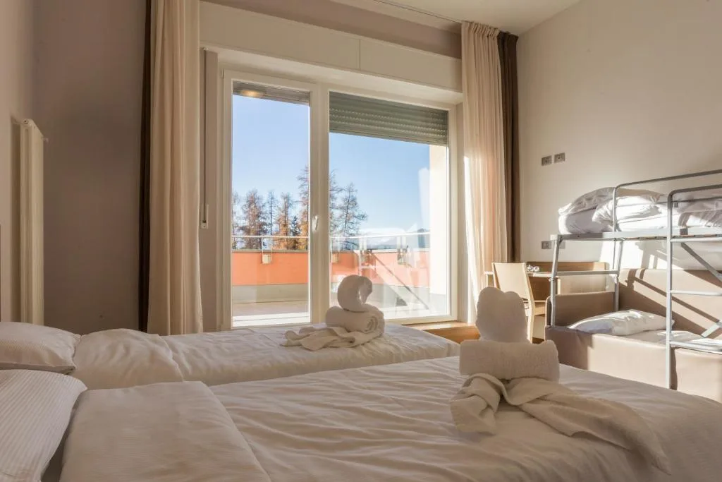 Camera familiare con letto matrimoniale, letto a castello e vista dalla finestra