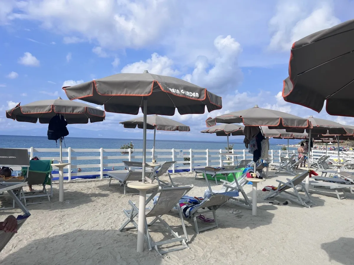 Ombrelloni grigi Green Garden e lettini sulla spiaggia con vista mare