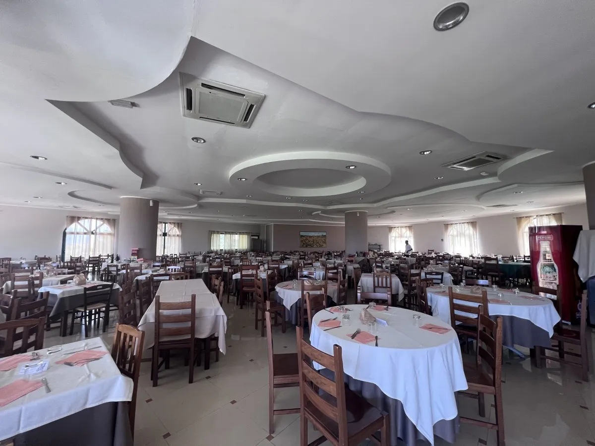 Ampia sala ristorante con tavoli apparecchiati e soffitto decorato
