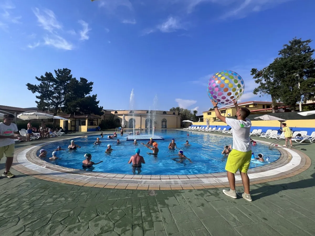 Animazione in piscina con bagnanti e grande palla colorata