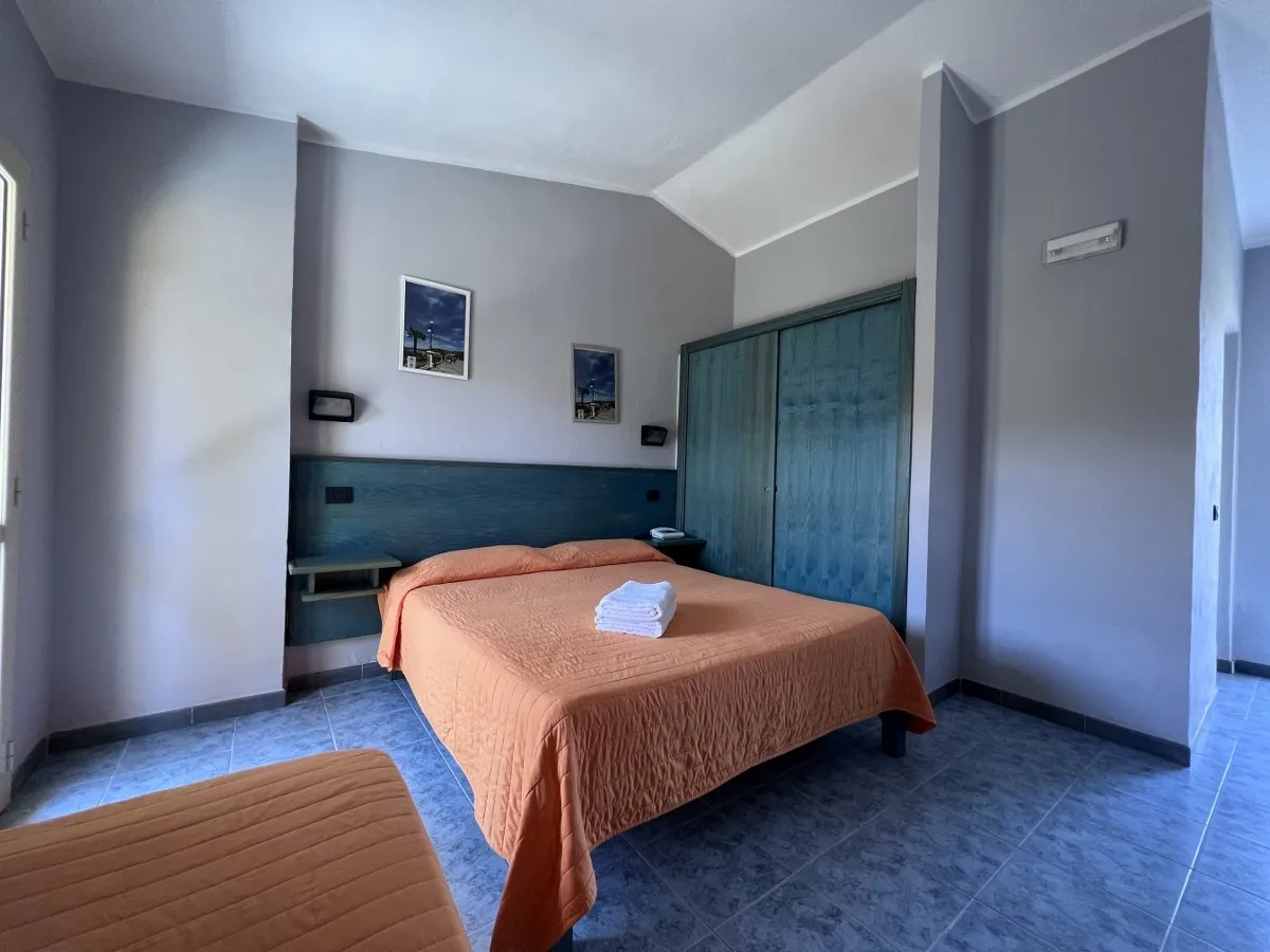 Camera con letto matrimoniale, armadio e arredi in legno azzurro