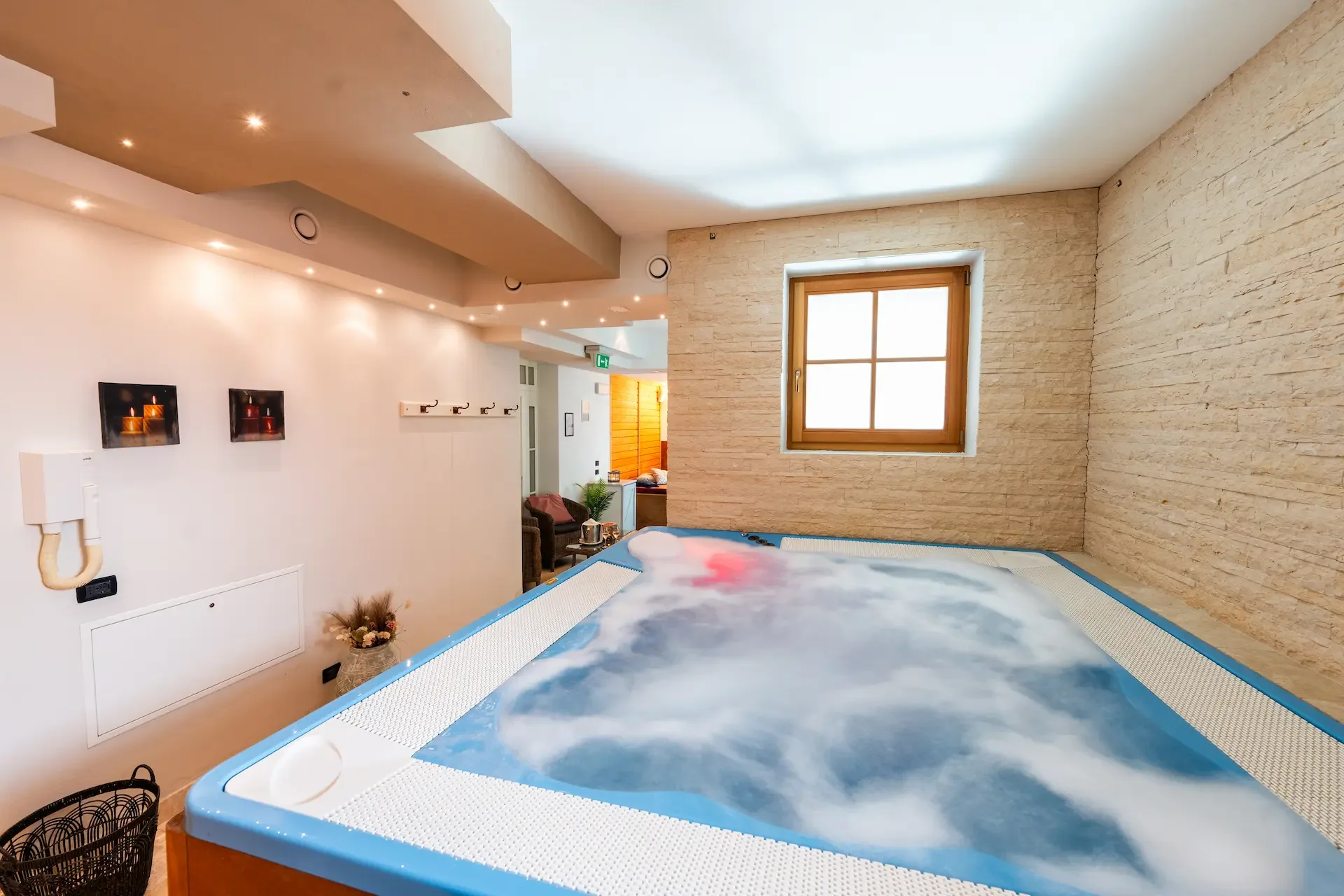 Vasca idromassaggio con acqua in movimento in ambiente spa con pareti in pietra chiara