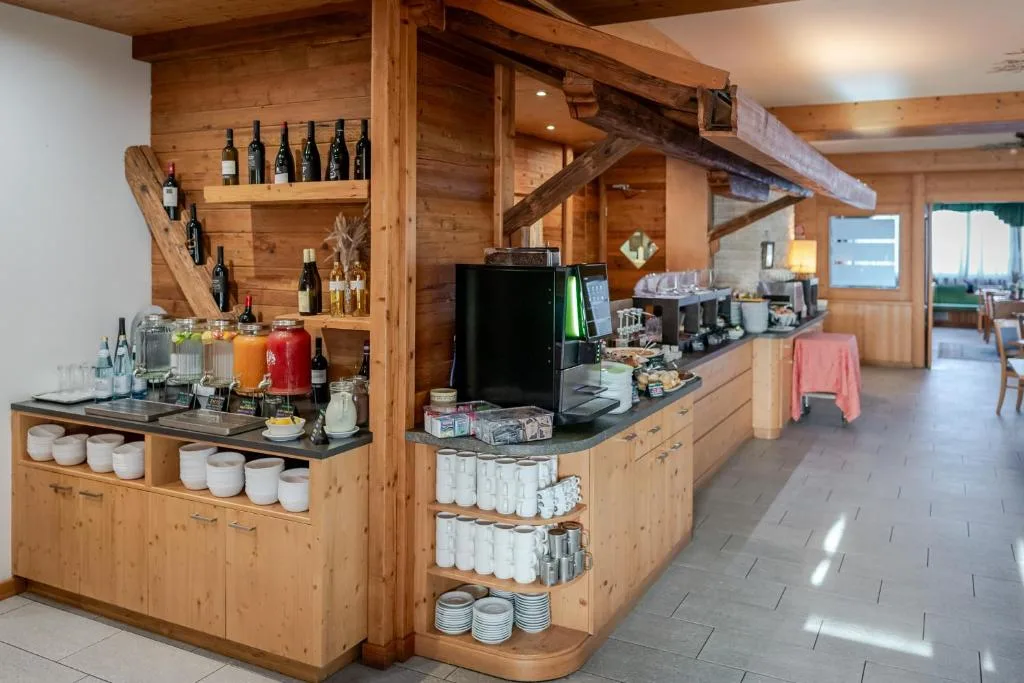 Buffet della colazione con bevande, macchina del caffè e stoviglie