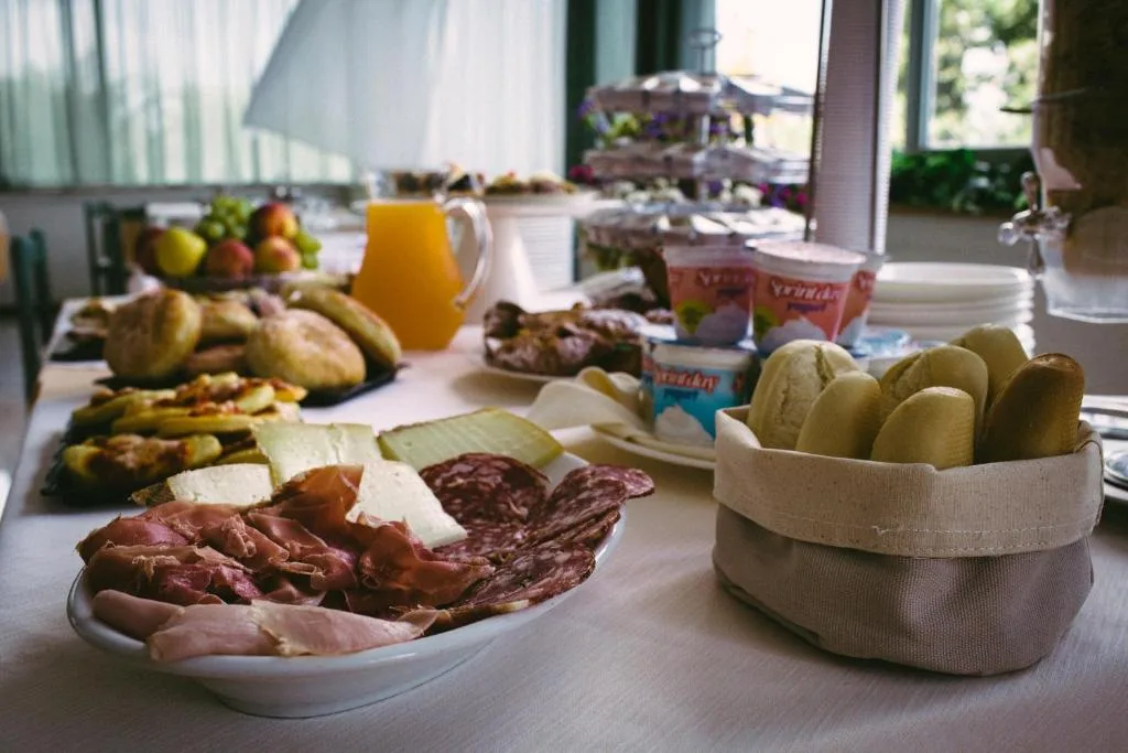Colazione a buffet con salumi, formaggi, pane, frutta e yogurt