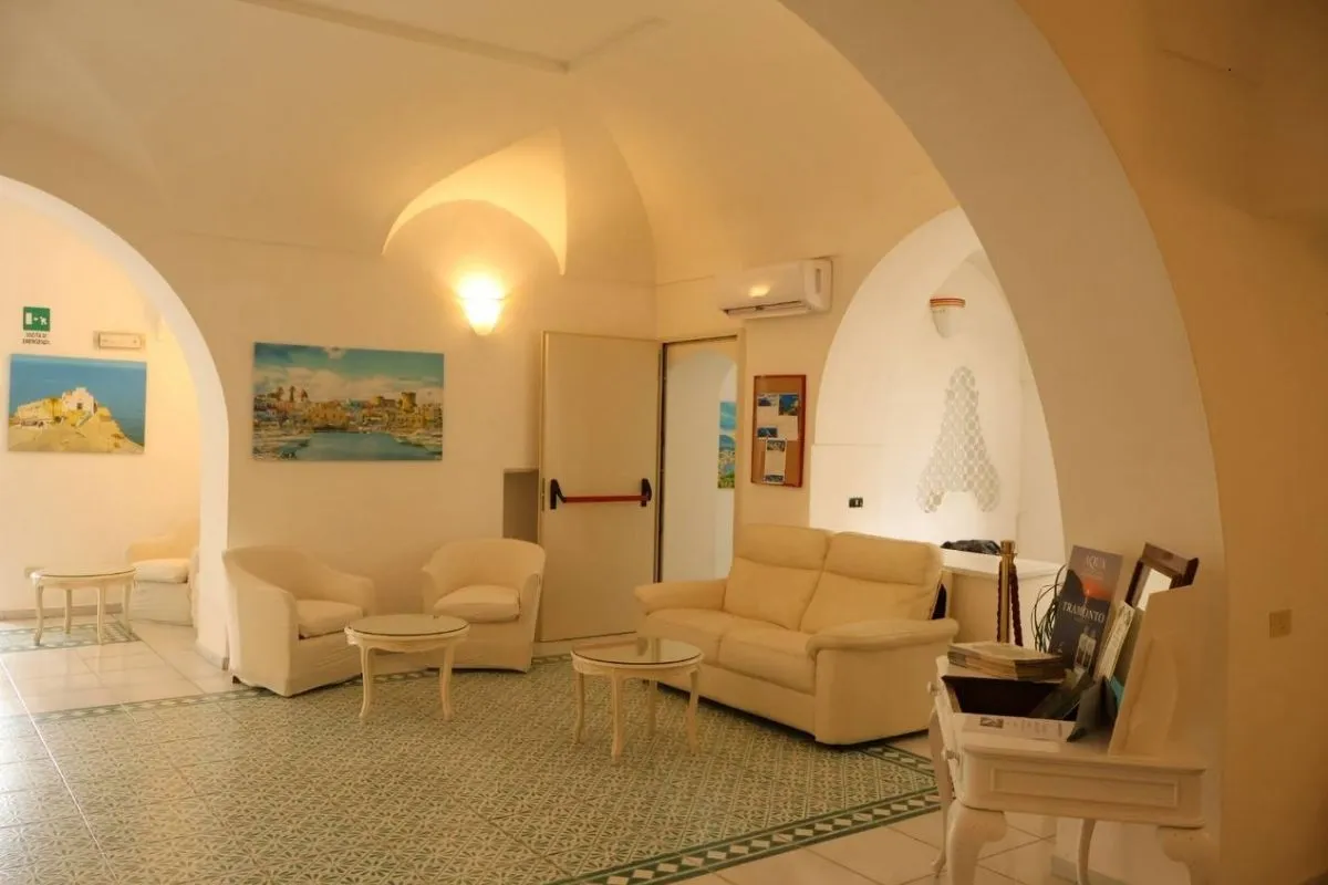 Salotto interno dell'hotel con poltrone, divano e archi caratteristici