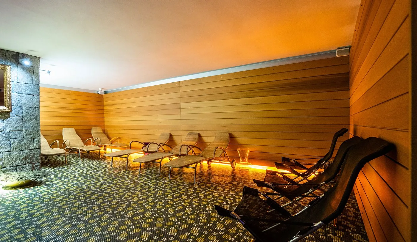 Zona relax della spa con lettini in legno e illuminazione soffusa