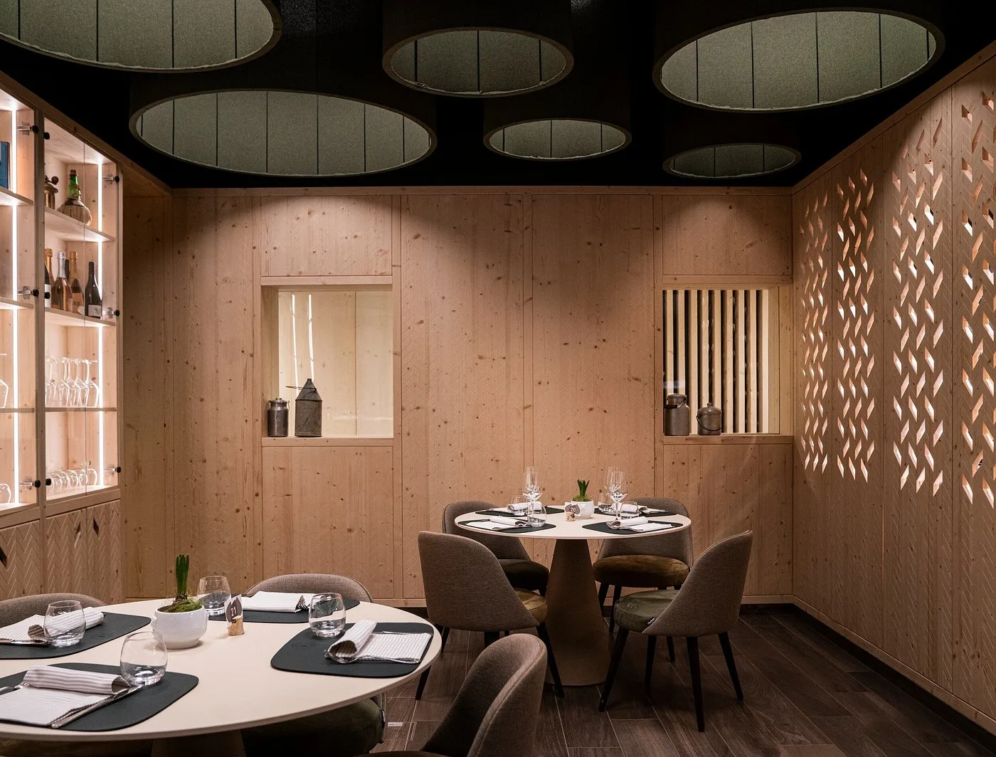Sala ristorante elegante con rivestimenti in legno e tavoli apparecchiati