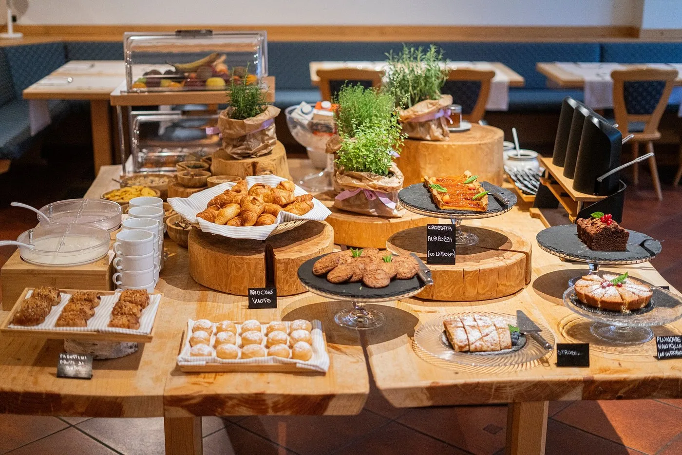 Ricco buffet della colazione con torte, croissant e dolci su piani in legno