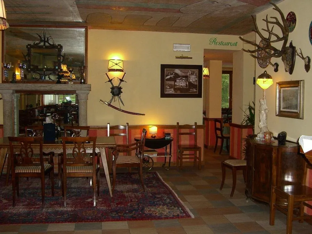 Sala interna in stile rustico con mobili antichi, specchio, tappeto e decorazioni con corna di cervo