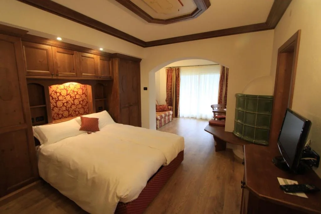 Camera con letto matrimoniale, mobili in legno e zona salotto