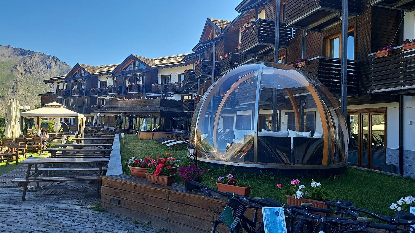 Cupola trasparente relax nel giardino dell'hotel con tavoli e fiori colorati