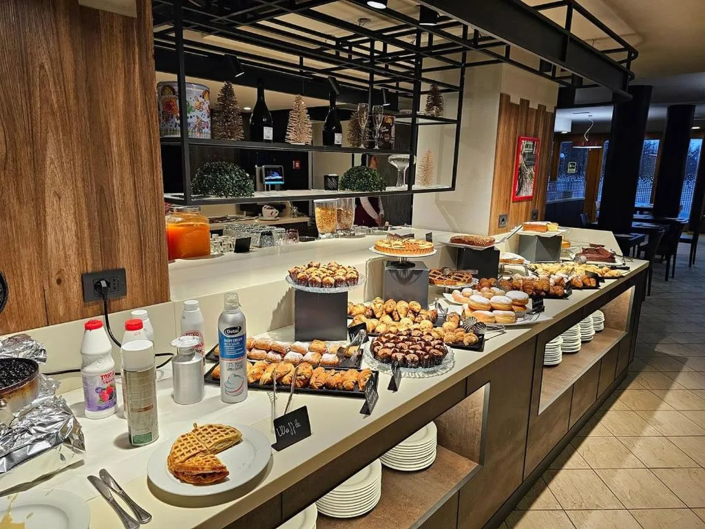 Buffet della colazione con dolci, cornetti, waffle e succhi di frutta