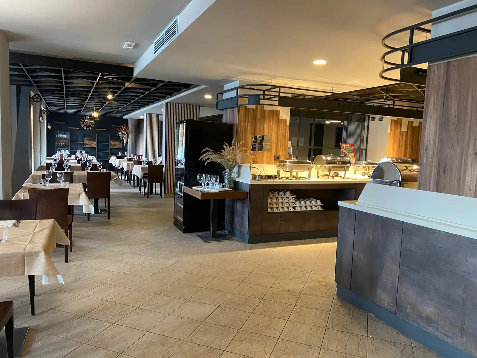Sala ristorante interna con tavoli apparecchiati e zona buffet