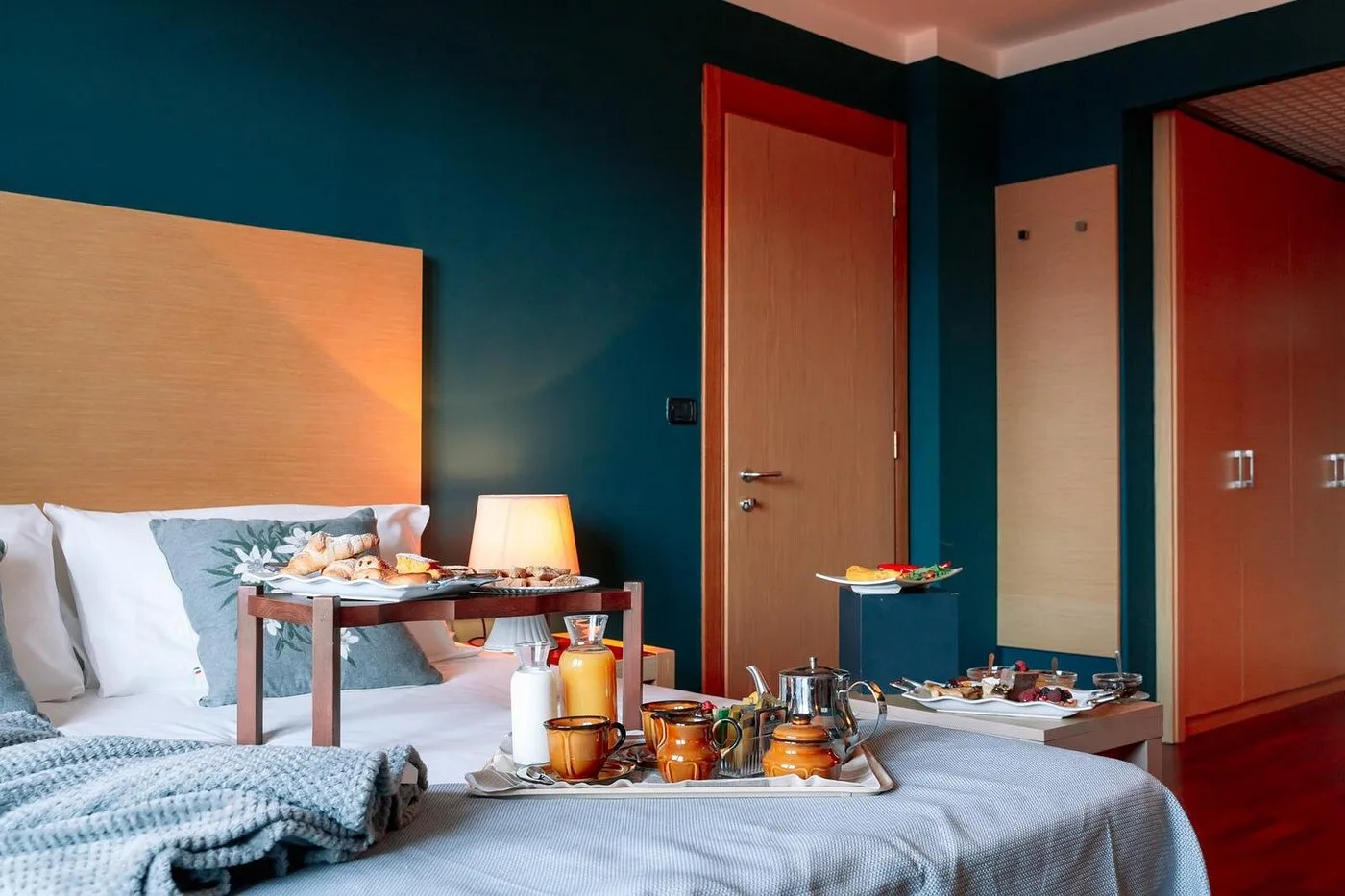Camera da letto elegante con pareti blu e colazione servita a letto
