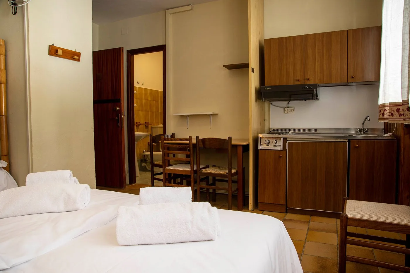 Monolocale con letto, angolo cottura e accesso al bagno