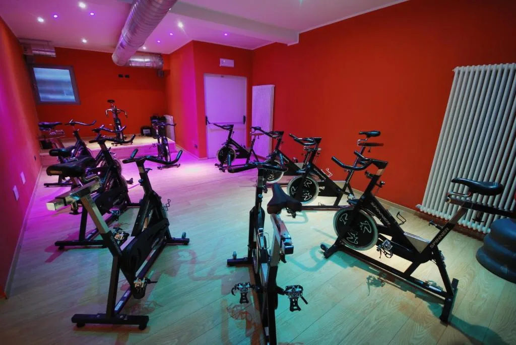 Sala spinning con cyclette e illuminazione rosa