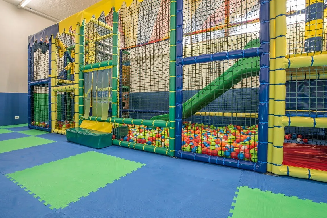 Area giochi coperta per bambini con struttura morbida e vasca con palline colorate