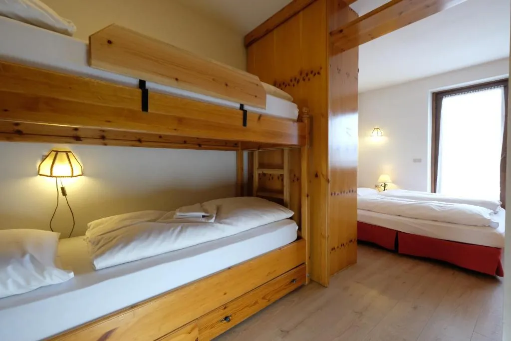 Camera con letto a castello in legno e letto matrimoniale