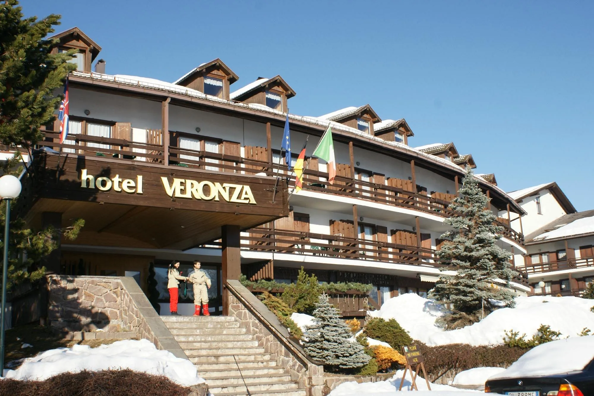 Ingresso dell'hotel Veronza con insegna, scala e neve invernale