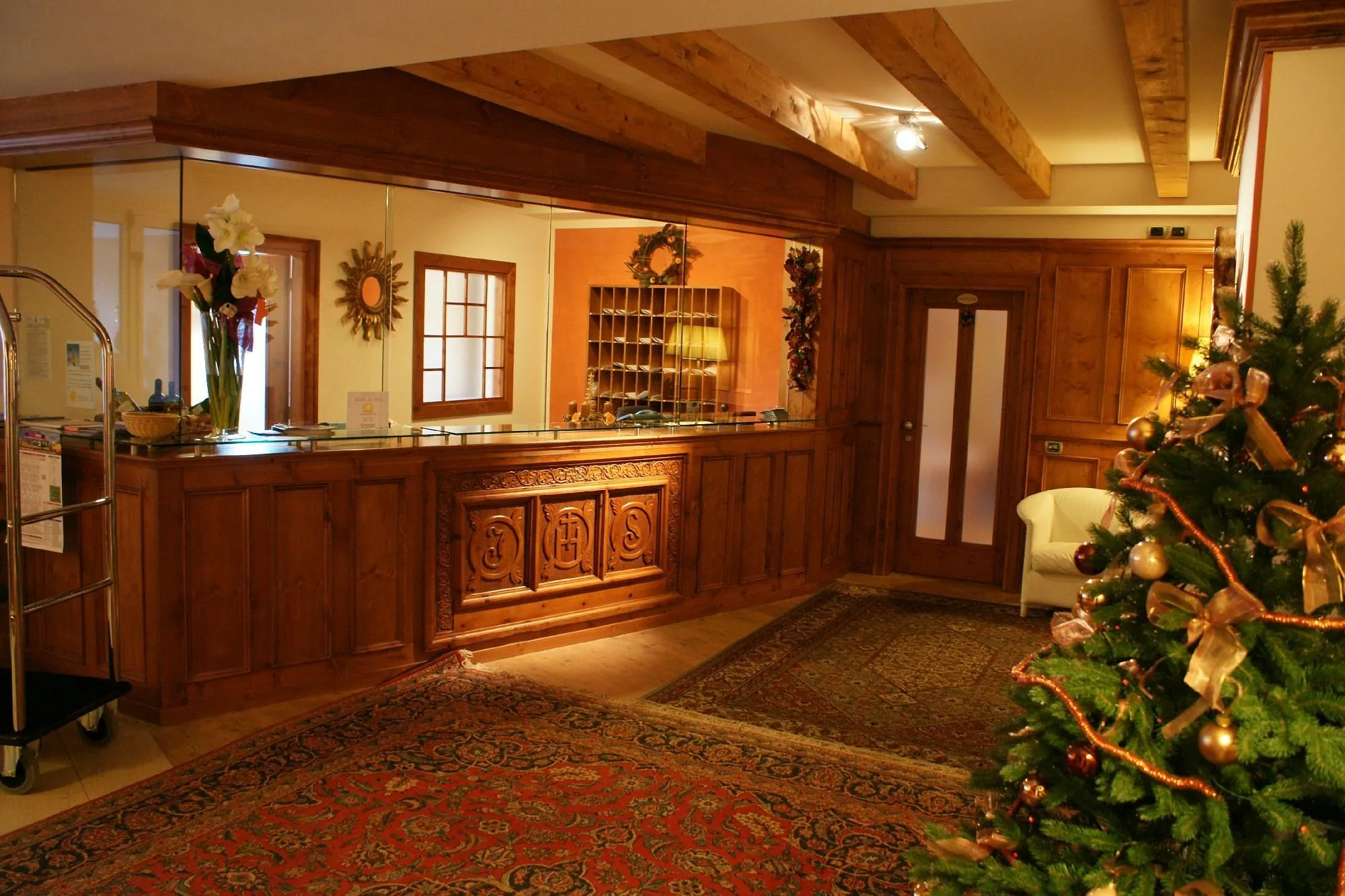 Reception in legno intagliato con albero di Natale e tappeto rosso