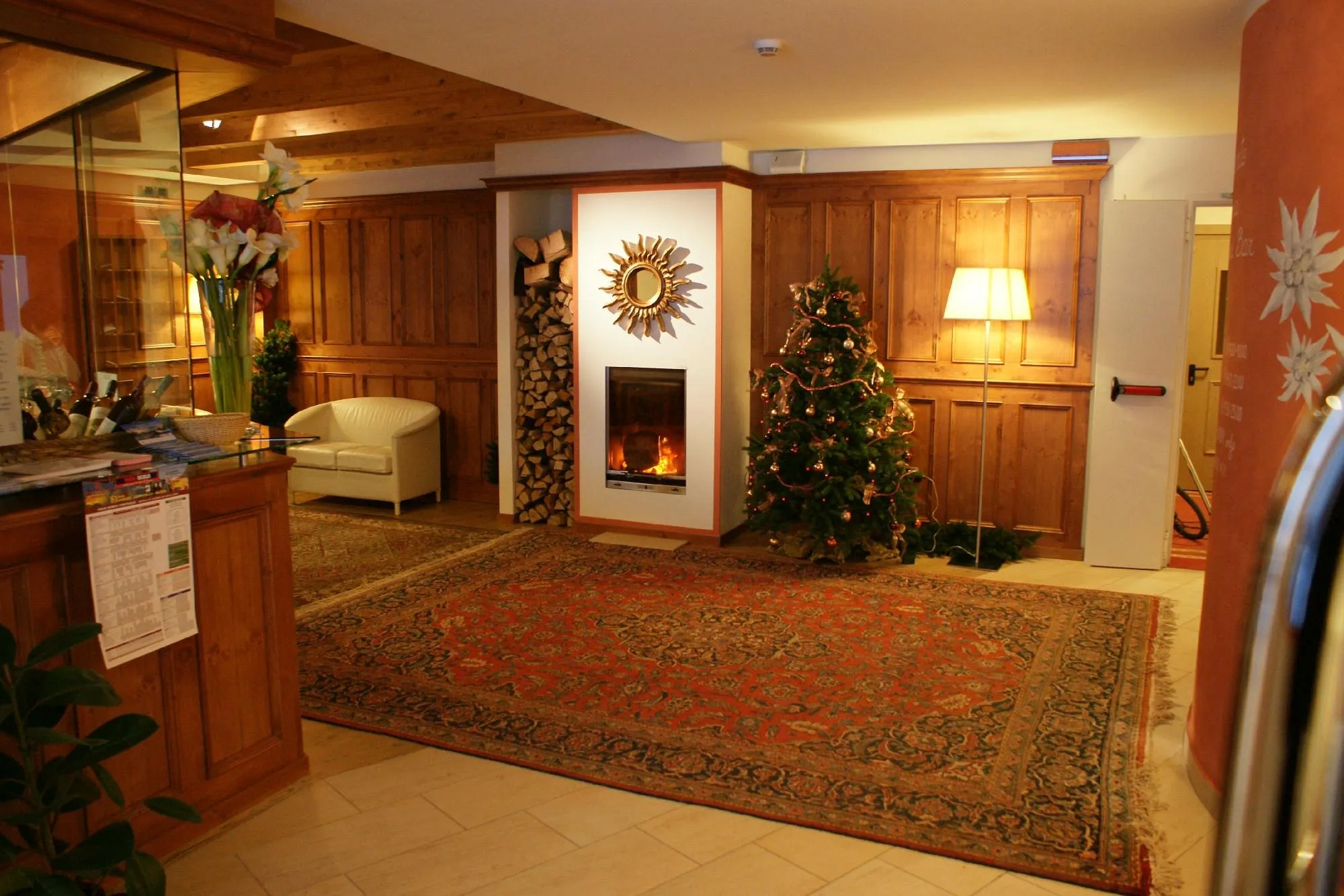Hall dell'hotel con camino acceso, albero di Natale e tappeto persiano
