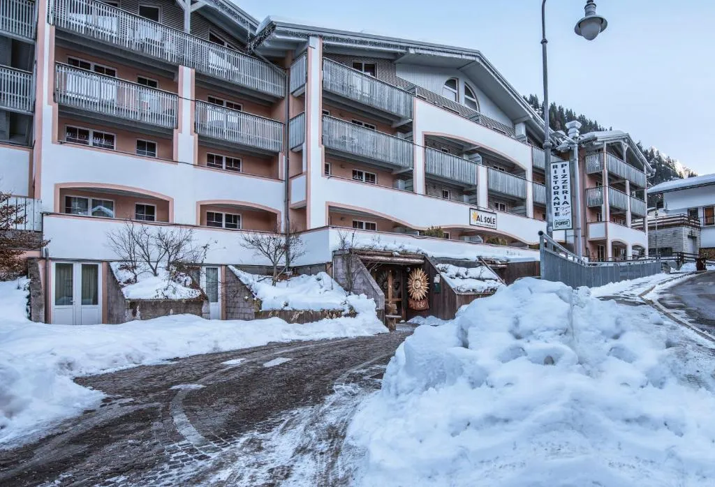 Facciata dell'hotel in inverno con neve e insegna del ristorante