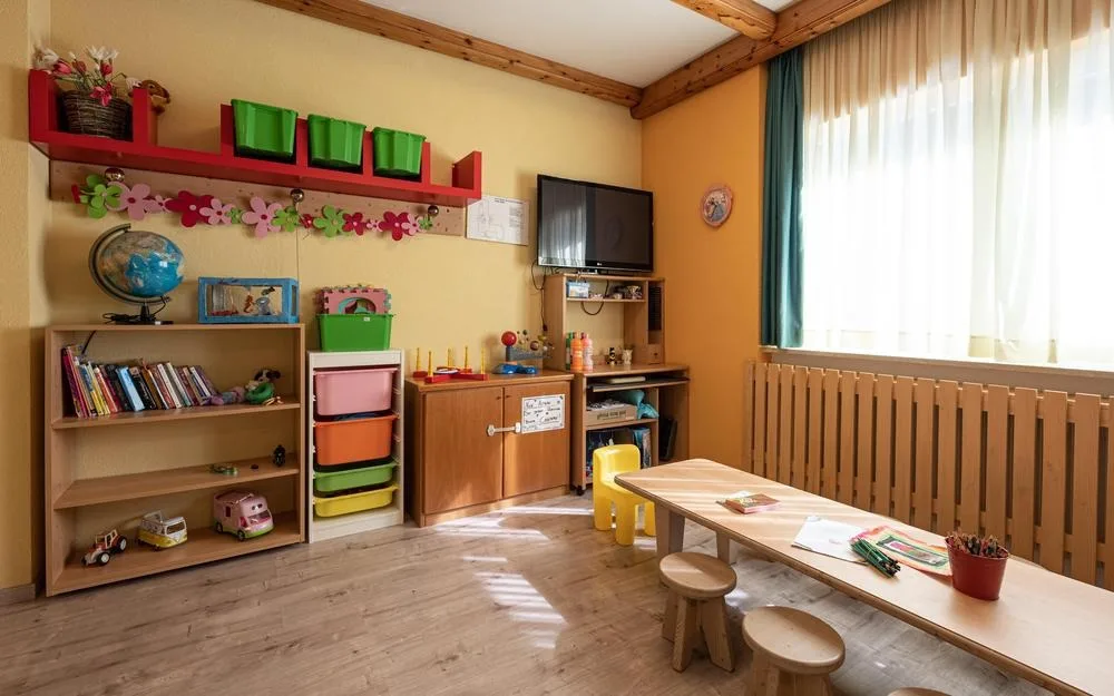 Sala giochi per bambini con giocattoli, libri e tavolino colorato
