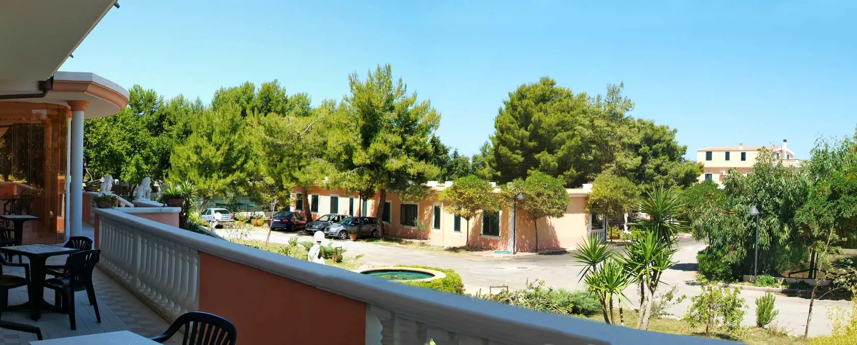 Terrazza con vista sul giardino, pini e parcheggio dell'hotel