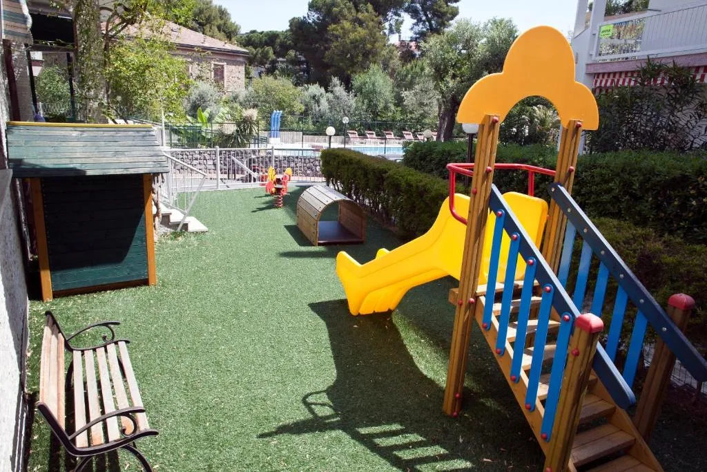 Area giochi per bambini all'aperto con scivolo colorato e prato sintetico