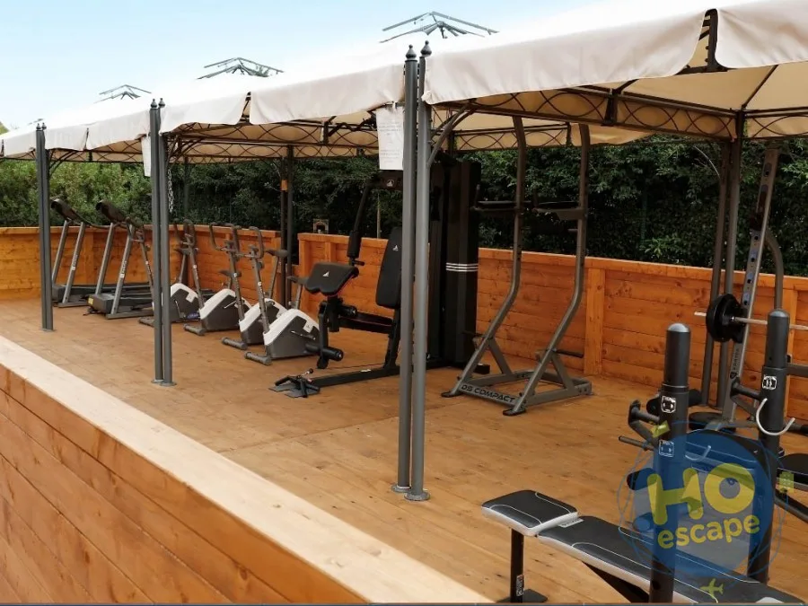 Palestra all'aperto attrezzata con macchinari sotto gazebo in legno