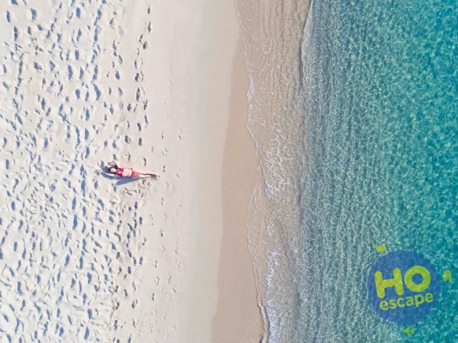 Vista aerea di spiaggia con sabbia bianca e mare turchese cristallino