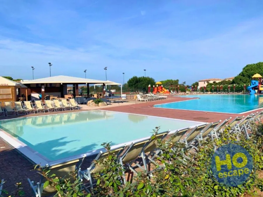 Complesso di piscine con lettini, bar e area giochi per bambini