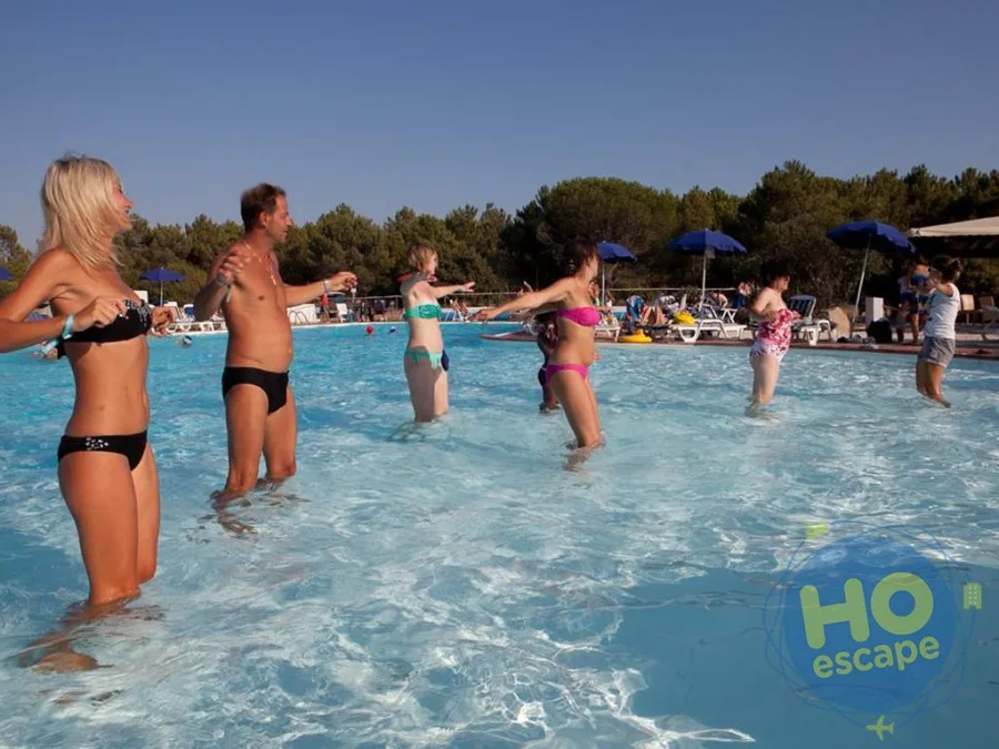 Persone che fanno acquagym in piscina sotto il sole