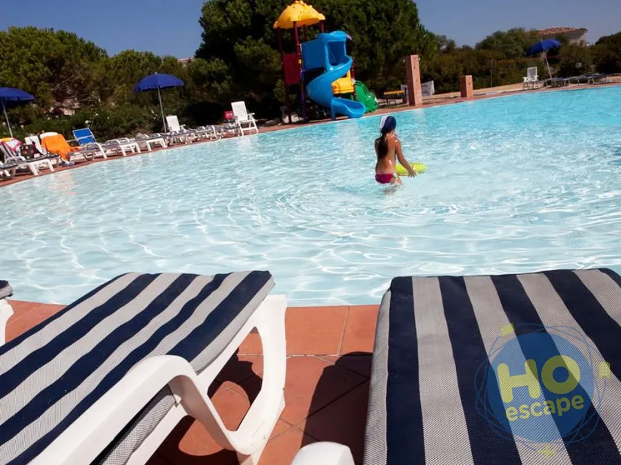 Piscina con area giochi acquatici per bambini e lettini a righe blu e bianche