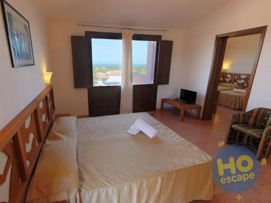 Suite con letto matrimoniale, area soggiorno e finestra con vista mare